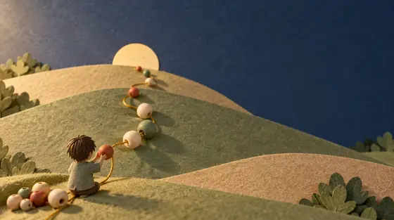 Motricité fine : un petit enfant en papier découpé enfile de grosses perles de bois sur un fil doré qui grimpe sur des collines de papier vert sauge vers un soleil